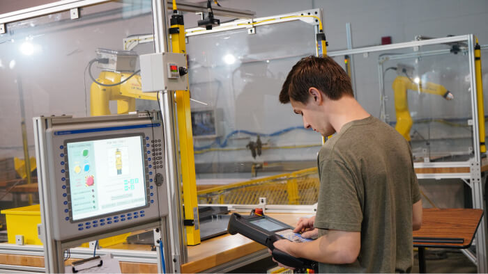 Student programming FANUC robot with teach pendant