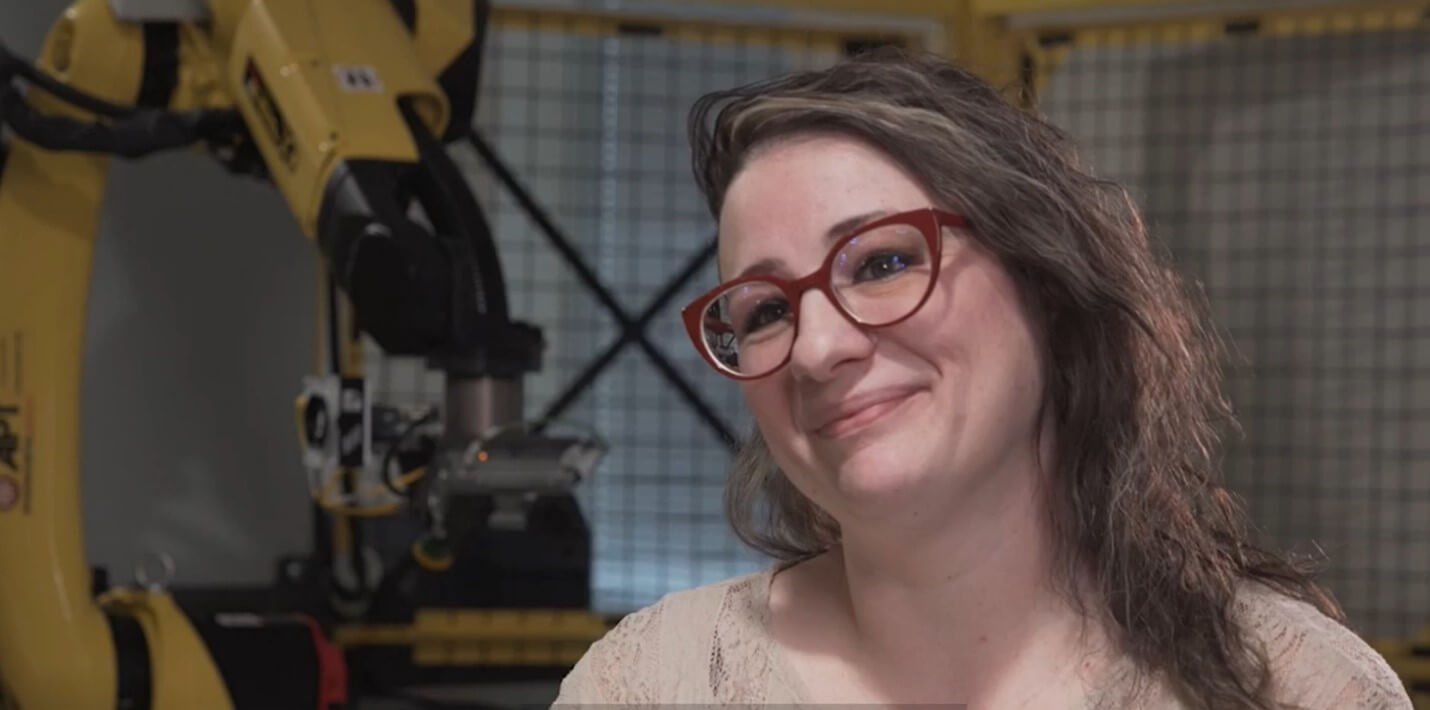 Tiffany Gillison being interviewed with FANUC robot in the background